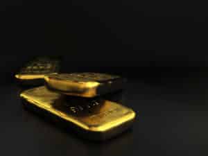 physical gold bullions ingots, golden bars over black background with room for text