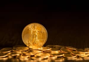 Gold Eagle one ounce coin against a golden background of other coins with focus on the Liberty symbol
